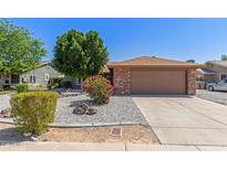 Charming single-story home featuring a low-maintenance desert landscape and a two-car garage at 6413 W Monte Cristo Ave, Glendale, AZ 85306