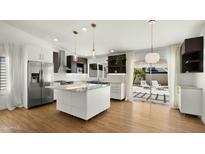 Modern kitchen with stainless steel appliances, island, and sliding door to the backyard at 6833 E Grandview Dr, Scottsdale, AZ 85254