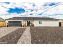 Charming single-story home with a gray garage door, manicured landscaping, and a paved walkway at 6908 W Wanda Lynn Ln, Peoria, AZ 85382
