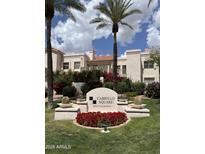 Cabrillo Square entrance with lush landscaping, palm trees, and red flowers offering curb appeal at 7800 E Lincoln Dr # 1035, Scottsdale, AZ 85250