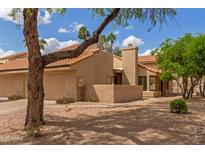 Tan single-story home with a red tile roof, desert landscaping, and mature trees, and blue skies with clouds at 1658 N Sierra Vista Dr, Tempe, AZ 85288