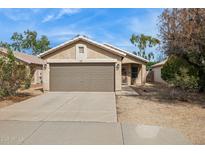 Charming single-story home featuring a two-car garage and low-maintenance desert landscaping at 16729 N 157Th Ave, Surprise, AZ 85374
