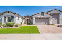 Charming single-story home boasts a well-manicured lawn and a neutral-toned exterior with a brick driveway at 21617 S 229Th Way, Queen Creek, AZ 85142