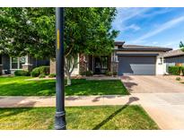 Charming single-story home featuring a well-manicured lawn and a two-car garage at 2900 E Spring Wheat Ln, Gilbert, AZ 85296