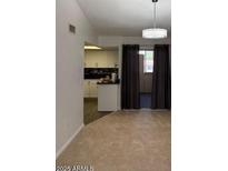 Inviting living room featuring neutral carpet, modern lighting, and seamless access to a well-appointed kitchen area at 461 W Holmes Ave # 374, Mesa, AZ 85210