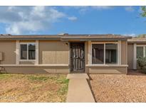 Home exterior with a desert landscape, pathway to a secure front door, and large windows at 6711 W Osborn Rd # 68, Phoenix, AZ 85033