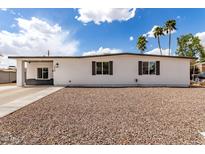 Charming single-story home with a low-maintenance rock front yard and white exterior paint under a clear sky at 1038 N 78Th Pl, Scottsdale, AZ 85257