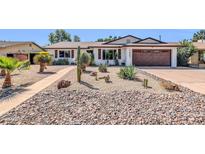 Charming single-story home with desert landscaping, rocks and cacti at 1643 W Harmont Dr, Phoenix, AZ 85021