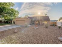 Inviting single-Gathering home featuring a gravel yard, mature trees, and a two-car garage at 19440 N 12Th St, Phoenix, AZ 85024