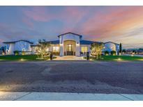 Beautiful custom home with professionally landscaped yard and decorative front entry at dusk at 447 W Judd Rd, San Tan Valley, AZ 85143