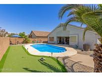 An aerial view of a backyard featuring a pool, putting green, and a covered patio, perfect for outdoor entertaining at 5432 N Ormondo Way, Litchfield Park, AZ 85340