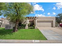 Inviting single-story home featuring a well-manicured lawn and charming desert landscaping at 6252 E Aire Libre Ln, Scottsdale, AZ 85254