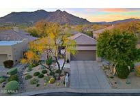 Stunning home exterior with desert landscaping and mountain views in the background at 6936 E Whispering Mesquite Trl, Scottsdale, AZ 85266