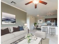 Cozy living room with white sofa, modern art, ceiling fan, and combined kitchen and eating area at 16013 S Desert Foothills Pkwy # 2055, Phoenix, AZ 85048