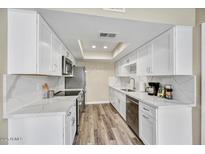 Modern kitchen with white cabinets, stainless steel appliances, and stylish countertops and flooring at 3154 E Clarendon Ave, Phoenix, AZ 85016