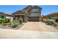 Beautiful two-story home showcasing a well-manicured front yard and brick driveway at 33275 N 132Nd Ave, Peoria, AZ 85383