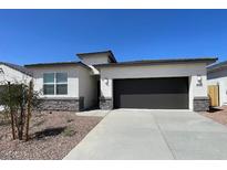 Beautiful single-story home featuring a neutral color palette, low maintenance landscaping, and a two-car garage at 5004 S 105Th Ln, Tolleson, AZ 85353