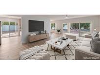 Bright living room with modern furniture, large TV, and sliding doors to the outdoor space at 5564 N 77Th Pl, Scottsdale, AZ 85250
