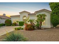 Charming exterior with stucco facade, tile roof, and vibrant desert landscaping at sunset at 7678 E Cactus Wren Rd, Scottsdale, AZ 85250
