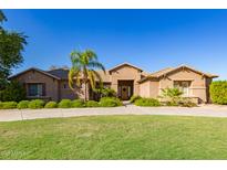Charming single-story home boasting a lush green lawn, mature trees, and inviting curb appeal on a sunny day at 14022 W Hope Dr, Surprise, AZ 85379
