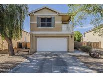 Two-story home with a balcony, a two-car garage, and desert landscaping at 14874 W Laurel Ln, Surprise, AZ 85379