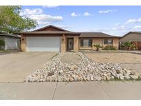 Charming single story home with a two-car garage and low maintenance desert landscaping at 15619 N 58Th Ave, Glendale, AZ 85306