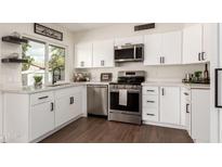 Bright kitchen with white cabinets, stainless appliances, and granite countertops provides a modern and clean cooking space at 1750 W Mohawk Ln, Phoenix, AZ 85027