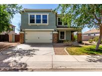 Inviting two-story home featuring stone accents, a two-car garage, and a well-maintained front yard at 1761 E 38Th Ave, Apache Junction, AZ 85119