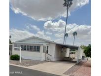 Well-maintained single-story home featuring a covered carport and low maintenance landscaping with desert surroundings at 201 S Greenfield Rd # 76, Mesa, AZ 85206