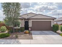 Charming single-story home with a well-maintained front yard and two-car garage at 21882 N 260Th Ln, Buckeye, AZ 85396