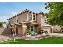 Charming two-story home featuring a welcoming porch with brick accents and well-maintained landscaping at 3874 E Fruitvale Ave, Gilbert, AZ 85297