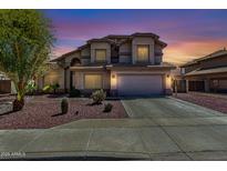 Inviting home featuring desert landscaping, a two-car garage, and a well-maintained lawn at 639 N 110Th Pl, Mesa, AZ 85207