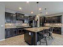 Gourmet kitchen with dark cabinets, granite countertops, an island with barstool seating and recessed lighting at 1197 W Fir Tree Rd, Queen Creek, AZ 85140