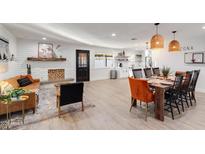 Open-concept living room and dining area boasts a cozy fireplace and stylish furnishings at 1307 E Encanto St, Mesa, AZ 85203