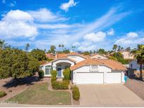Charming single-story home with a well-manicured lawn and a two car garage in a sunny neighborhood at 14241 N 56Th Pl, Scottsdale, AZ 85254