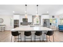 Contemporary kitchen with a large island, modern appliances, and stylish pendant lighting at 14241 N 56Th Pl, Scottsdale, AZ 85254