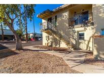 View of condo building featuring wrought iron stairs and walkway through desert landscaping on a bright sunny day at 14261 N Oakwood Ln, Fountain Hills, AZ 85268
