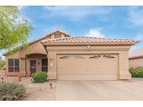 Charming single-story home featuring a two-car garage and desert landscaping with a tiled roof at 17128 E Kensington Pl, Fountain Hills, AZ 85268
