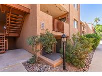 Condo exterior featuring stairs and a small patio with rock landscaping and a decorative lamp post at 3031 N Civic Center Plz # 112, Scottsdale, AZ 85251