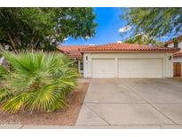 Charming single-story home with a two-car garage, beautiful desert landscaping, and a classic red tile roof at 5428 W Wethersfield Dr, Glendale, AZ 85304