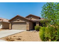 Charming single-story home with a two-car garage, tile roof, and a low-maintenance desert landscape at 672 S Porter St, Gilbert, AZ 85296