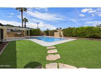 Lush backyard features pool, grass, and outdoor BBQ, perfect for entertaining at 7502 E Princeton Ave, Scottsdale, AZ 85257