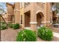 Charming condo exterior featuring a covered entry and well-maintained landscaping at 14250 W Wigwam Blvd # 2111, Litchfield Park, AZ 85340
