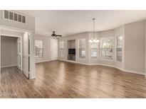 Bright living room with wood-look floors, neutral walls, and multiple windows at 14250 W Wigwam Blvd # 2111, Litchfield Park, AZ 85340