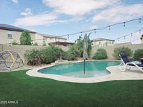 Beautiful backyard pool with artificial grass and a lounge chair perfect for relaxing at 16810 W Portland St, Goodyear, AZ 85338