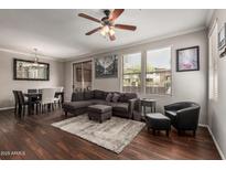 Inviting living room featuring a plush gray sectional, ceiling fan, and dark wood floors at 19777 N 76Th St # 1131, Scottsdale, AZ 85255