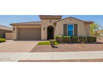 Inviting single-story home featuring a desert landscape, brick-paved driveway, and neutral-toned facade at 2792 N Acacia Way, Buckeye, AZ 85396