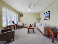 Bright living room with plush seating, ceiling fan, and large window bringing natural light to this spacious home at 3108 W Butler Dr, Phoenix, AZ 85051