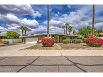 Charming single-story home featuring mature landscaping, flowering bushes, and a well-maintained lawn at 3954 E Becker Ln, Phoenix, AZ 85028