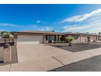 Well-maintained home with a spacious driveway, desert landscaping, and attached garage at 6722 E El Paso St, Mesa, AZ 85205